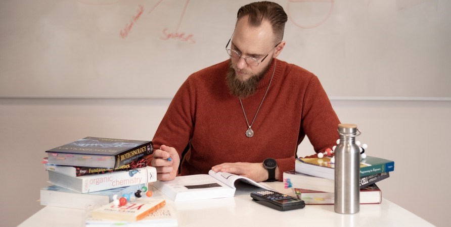 Man som sitter vid b�cker och antecknar.